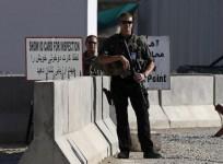 Afghan and foreign security personnel stand guard at the site of a blast, outside the counter-narcotics office near the Kabul International Airport