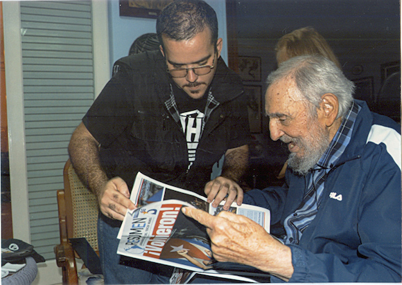 Former Cuban President Fidel Castro and President of Cuba's University Students Federation (FEU) Randy Perdomo look at a newspaper during a meeting in Havana in this picture provided by Cubadebate. Former Cuban President Fidel Castro