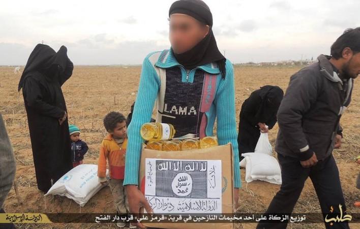 A Syria refugee carries a cardboard box containing food parcel distributed by ISIS. The images shows that the Islamic State has pasted its logo over the WFP label.