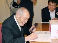 Sakari Momoi (L), a resident of Saitama prefecture, writes a message to communicate with Saitama Mayor Hayato Shimizu (R) in Tokyo, in this Kyodo file photo taken September 2013.