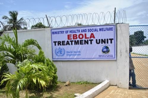 A man stands at the gate of an Ebola virus treatment center in Monrovia, Liberia. Ebola treatment