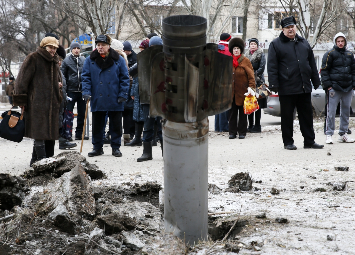 People look at the remains of a rocket shell on a street in the town of Kramatorsk, eastern Ukraine February 10, 2015. Ukraine