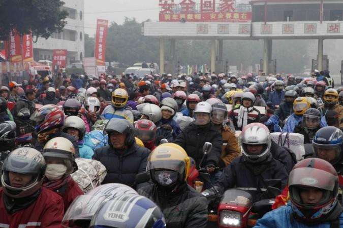 Migrant workers ride their motorcycles with families and friends, as they past a checkpoint on their way home for the upcoming Spring Festival, on a hazy day in Fengkai county, Guangdong province, February 12, 2015 Migrant workers ride their motorcycles with families and friends, as they past a checkpoint on their way home for the upcoming Spring Festival, on a hazy day in Fengkai county, Guangdong province, February 12, 2015