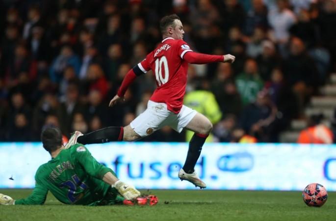 Preston's Thorsten Stuckmann (L) concedes a penalty against Manchester United's Wayne Rooney during the two sides' fifth round FA Cup clash on Mondat Wayne Rooney
