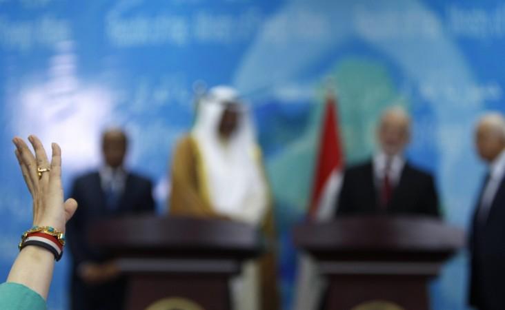 A journalist raises her hand to ask a question during a news conference in Baghdad
