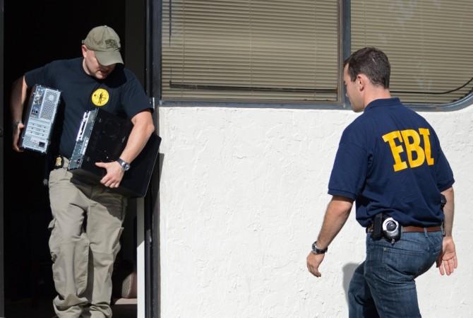 Law enforcement officers remove computer hard drives as part of their investigations. FBI Agent