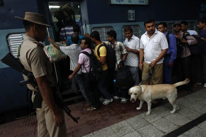 A Railway Protection Force (RPF) officer uses a sniffer dog to check bags of passengers before their boarding on a train at a railway station in Kolkata July 8, 2014. Indian Prime Minister Narendra Modi's government disappointed markets with its first major economic policy statement on Tuesday, promising to seek foreign and private funding for the railways but giving no details of how it would lure investors. India's state-owned railways are the fourth-largest in the world. They have suffered from years of low investment and populist policies that have kept fares low. Railway Protection Force (RPF)