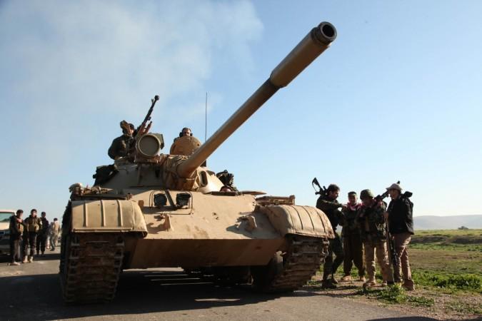 Kurdish Peshmerga fighters walk next to their tank as they take control of the area, on the outskirts of Mosul February 6, 2015. Kurdish Peshmerga fighters walk next to their tank as they take control of the area, on the outskirts of Mosul February 6, 2015.