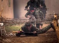 Fighters of the Kurdish People's Protection Units (YPG) crawl under barbed wires with their weapons at a military training camp in Ras al-Ain February 13, 2015.