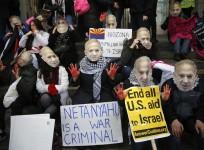 Anti-Israel demonstrators led by the protest group Code Pink wear masks of Israeli Prime Benjamin Netanyahu as they sit at the entrance to the American Israel Public Affairs Committee (AIPAC) policy conference at the Washington Convention Center in Washin
