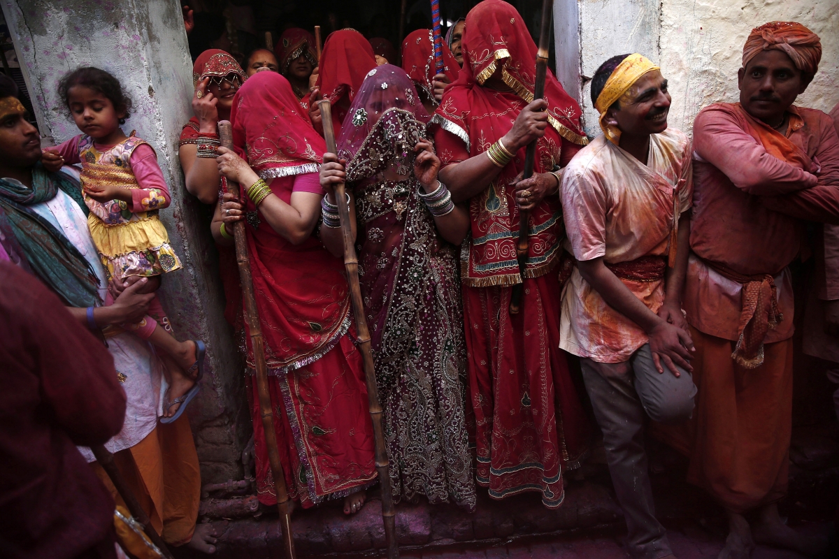 A group of veiled women wait to beat men with sticks during Holi 2015: Spectacular Images of 'Lathmar Holi' Celebrated in Mathura, Vrindavan