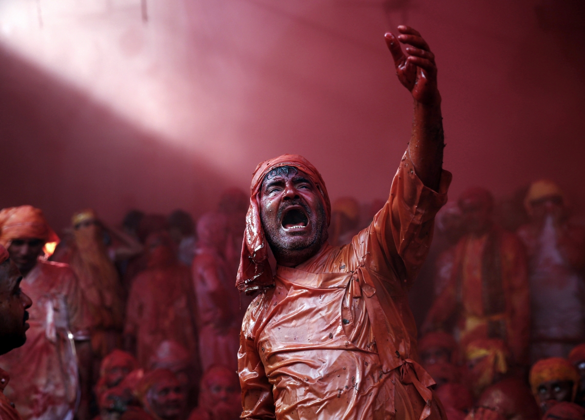 A man daubed in colours sings religious songs as he celebrates Holi 2015: Spectacular Images of 'Lathmar Holi' Celebrated in Mathura, Vrindavan