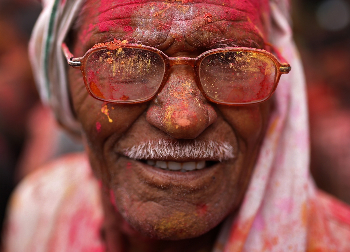 A man with his face daubed in colours celebrates Holi 2015: Spectacular Images of 'Lathmar Holi' Celebrated in Mathura, Vrindavan