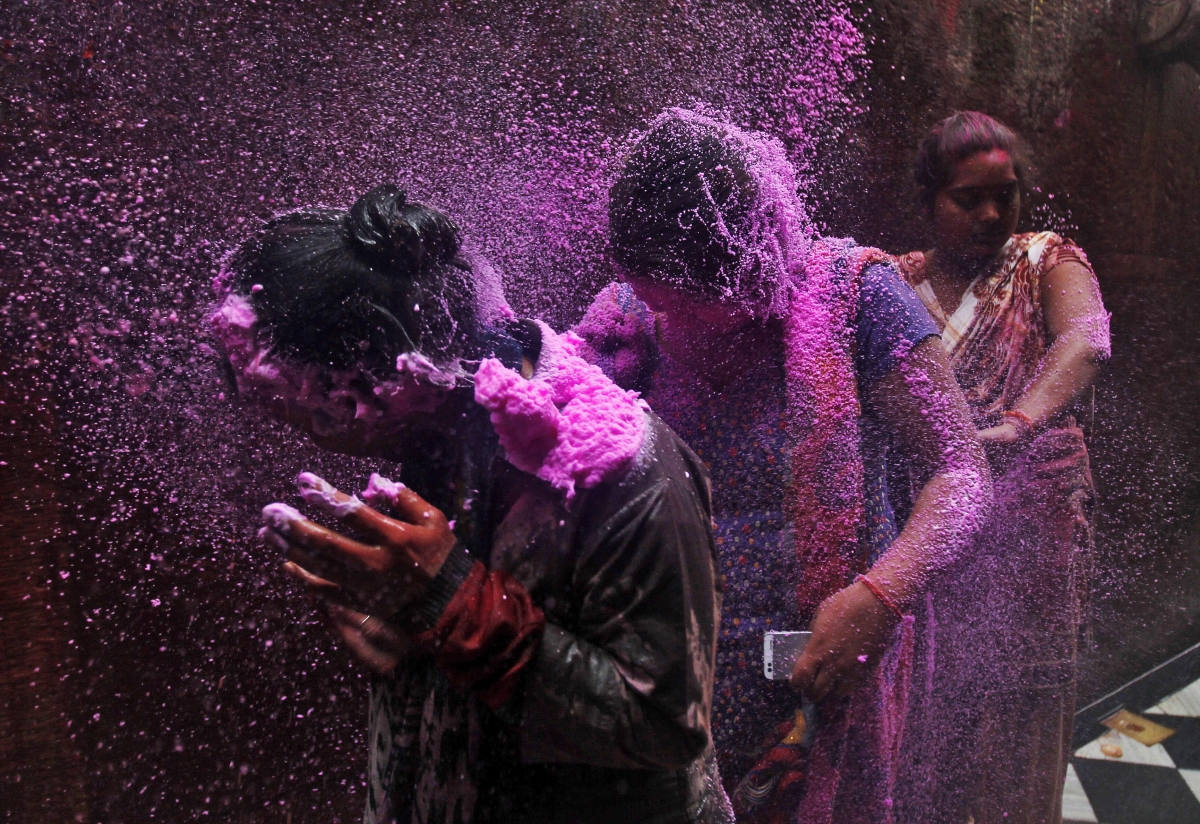 People spray coloured foam on women as they walk in a lane near the Bankey Bihari temple during Holi celebrations in Vrindavan Holi 2015: Spectacular Images of 'Lathmar Holi' Celebrated in Mathura, Vrindavan