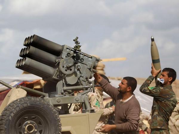 Iraqi security forces and Shia fighters reload a weapon during clashes with Islamic State militants in Salahuddin province March 2, 2015.