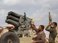 Iraqi security forces and Shia fighters reload a weapon during clashes with Islamic State militants in Salahuddin province March 2, 2015.