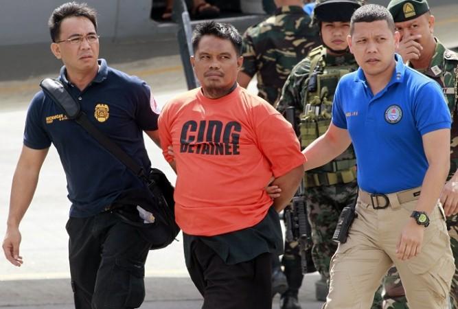 Members of the Philippine National Police (PNP) intelligence escort Mohammad Ali Tambako (C), founder and leader of the Justice Islamic Movement, upon arrival at Villamor Air Base in Manila March 16, 2015. Members of the Philippine National Police (PNP) intelligence escort Mohammad Ali Tambako (C), founder and leader of the Justice Islamic Movement, upon arrival at Villamor Air Base in Manila March 16, 2015.
