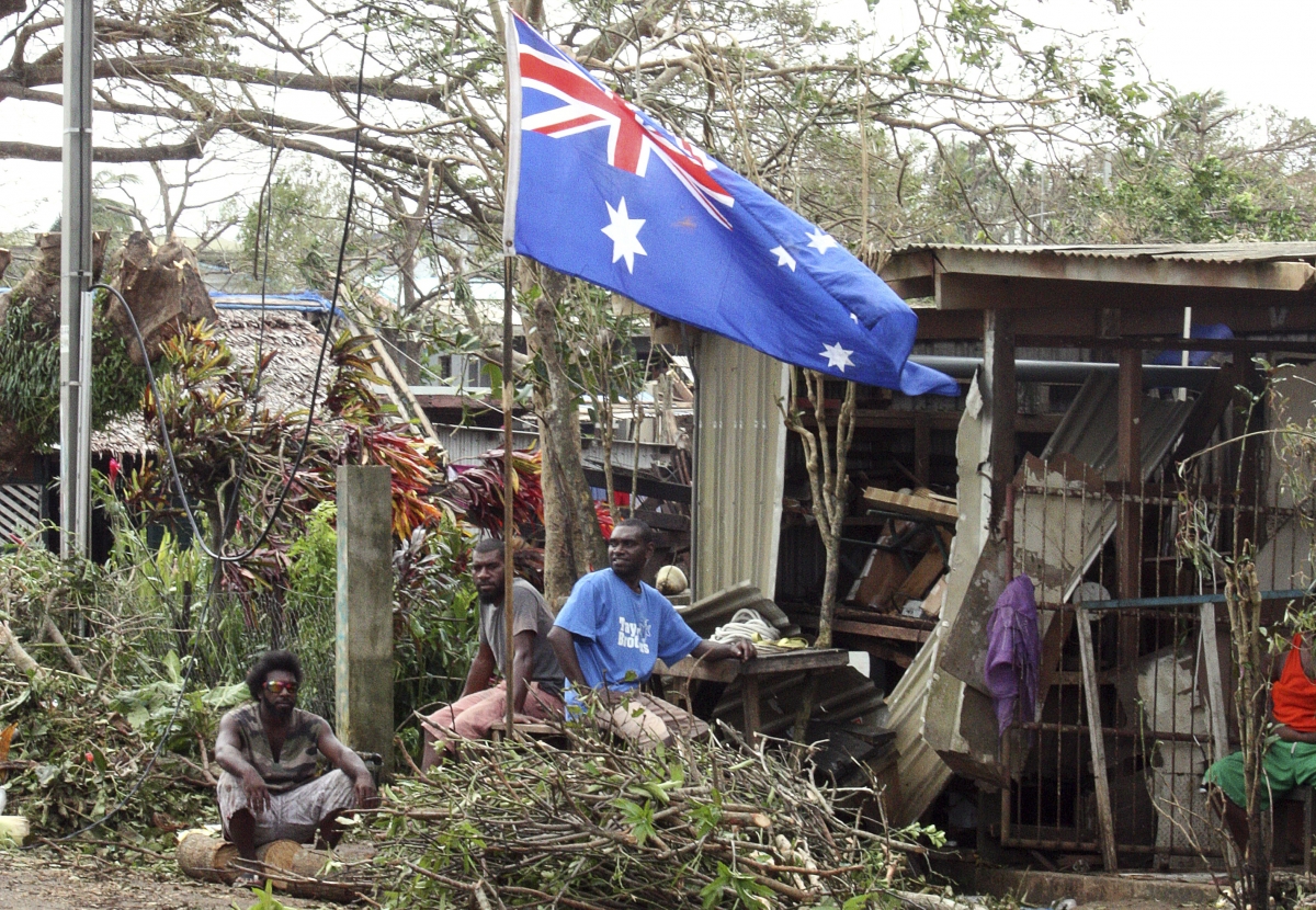 Local residents sit outside their damaged homes surrounded by debris on a street after Cyclone Pam hit Port Vila, the capital city of the Pacific island nation of Vanuatu March 15, 2015. Vanuatu cyclone Pam
