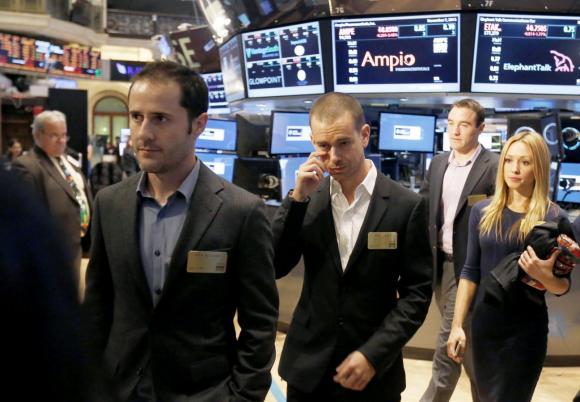 Twitter co-founders Evan Williams (L) and Jack Dorsey (C) walk together during the Twitter Inc. IPO on the floor of the New York Stock Exchange in New York, November 7, 2013.