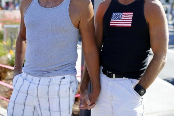 A gay couple hold hands during a rally in support of the United States Supreme Court