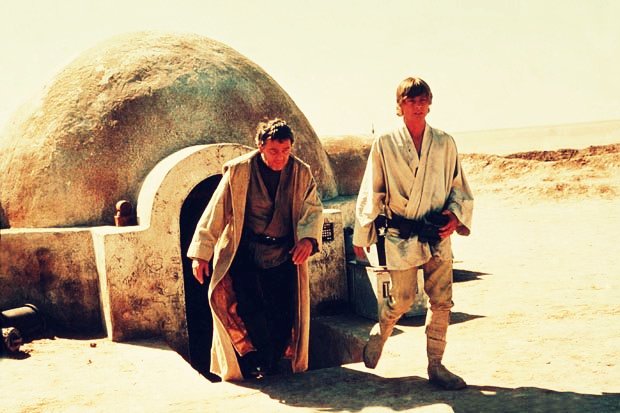 Luke Skywalker pictured with his uncle coming out of their house in 1977's Star Wars