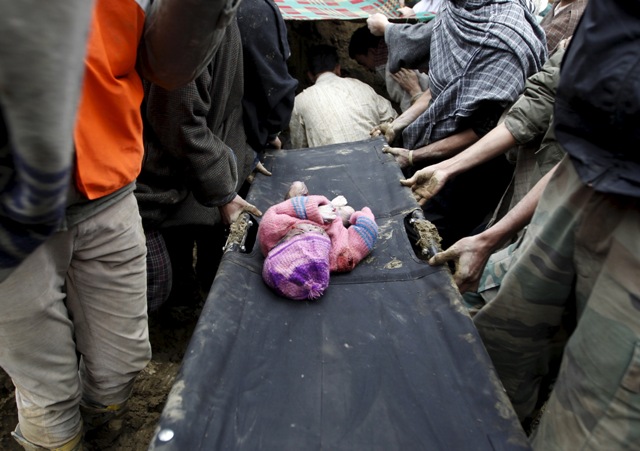 The body of a child lies on a stretcher after it was pulled out from the rubble after a hillside collapsed onto a house at Laden village, west of Srinagar. Kashmir Floods