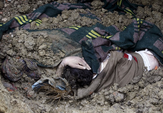 An unidentified body of a victim lies in the rubble after a hillside collapsed onto a house at Laden village, west of Srinagar. Kashmir Floods