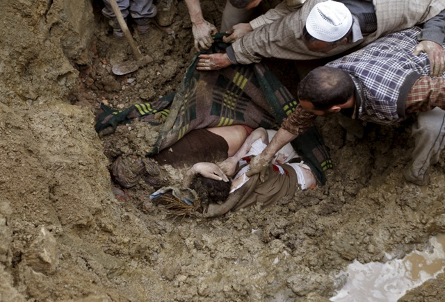 Villagers try to pull the bodies of victims from the rubble after a hillside collapsed onto a house at Laden village, west of Srinagar. Kashmir Floods