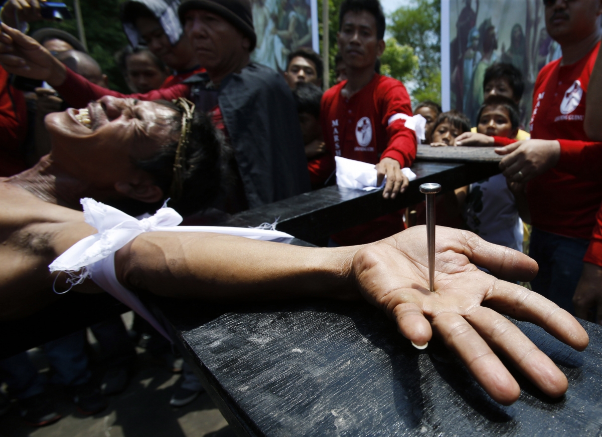 Penitent Danilo Ramos grimaces in pain as he is nailed to a wooden cross during the reenactment of the death of Jesus Christ on Good Friday in San Fernando, Pampanga in northern Philippines April 18, 2014. Penitents are nailed to wooden crosses on Good Friday which is the most extreme display of religious devotion in the Philippines, a predominantly Catholic country. Penitent Danilo Ramos grimaces in pain as he is nailed to a wooden cross during the reenactment of the death of Jesus Christ on Good Friday in San Fernando, Pampanga in northern Philippines April 18, 2014. Penitents are nailed to wooden crosses on Good Fr
