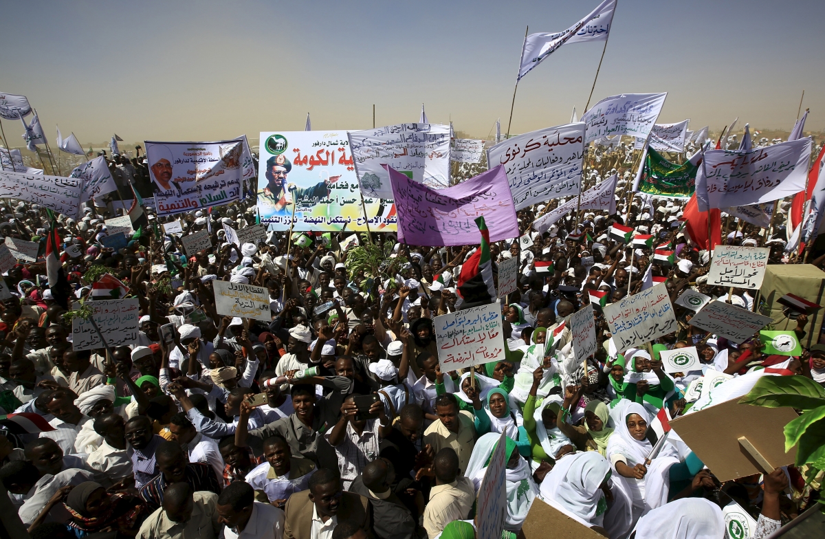Supporters of the National Congress Party's (NCP) presidential candidate, Sudan's President Omar Hassan al-Bashir wave while gathering during a campaign rally at Al Fashir in North Darfur, ahead of the 2015 elections, April 8, 2015. Sudan elections