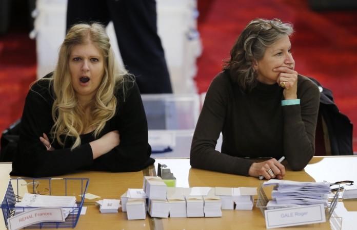 A vote counter yawns as she waits during a delay in counting at Winter Gardens in Margate, southeast England, May 8, 2015. Uk election