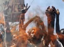 Protesters are seen behind a fire barricade as they chant anti-government slogans before clashing with riot police in Burundi's capital Bujumbura, April 28, 2015.