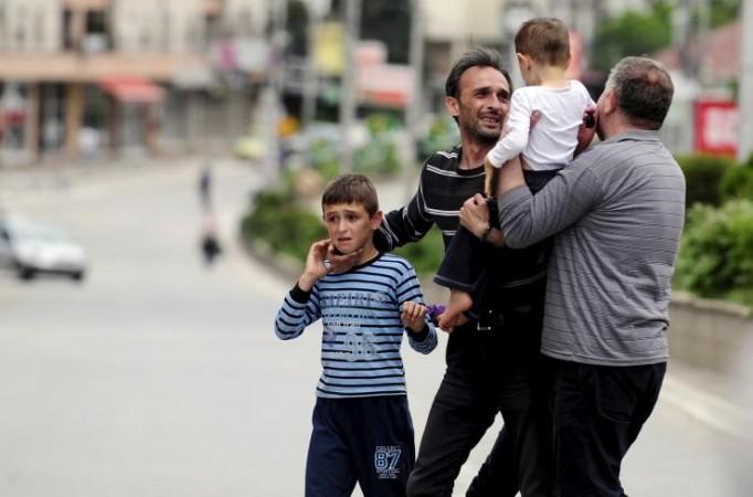 A man reunites with his family members after they were rescued by the police near a police checkpoint in Kumanovo, Macedonia May 9, 2015.