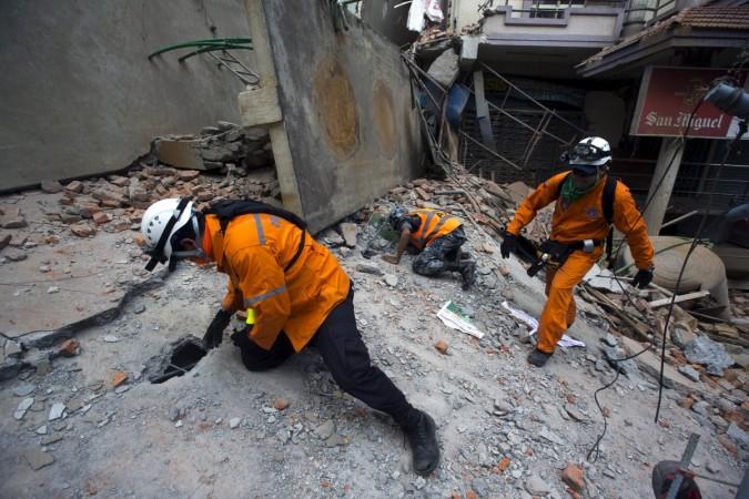 Nepalese military personnel and international rescue check on a collapsed building after an earthquake in Kathmandu on May 12, 2015. Earthquake again
