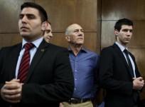 Former Israeli Prime Minister Ehud Olmert (2nd R) waits to hear his verdict at the Tel Aviv District Court March 31, 2014.