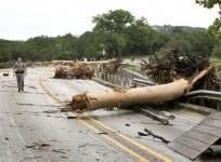 Department of Public Safety Trooper Marcus Gonzales walks on the Highway 12 bridge over the Blanco River which was blocked by large trees after flooding in Wimberly, Texas, United States May 24, 2015.