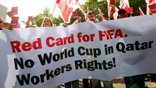 Members of the Swiss UNIA workers union display red cards and shout slogans during a protest