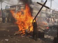 A demonstrator burns a cross during a protest in the Badami Bagh area of Lahore, Pakistan
