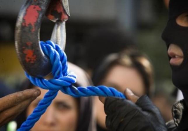An Iranian executioner checks the rope before a public hanging.