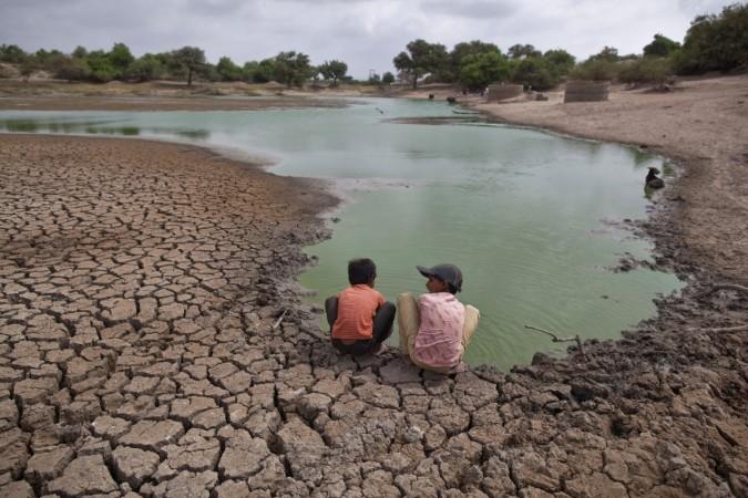 Children wash their hands in a partially dried-out natural pond at Badarganj village, in the western Indian state of Gujarat,