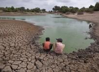 Children wash their hands in a partially dried-out natural pond at Badarganj village, in the western Indian state of Gujarat,