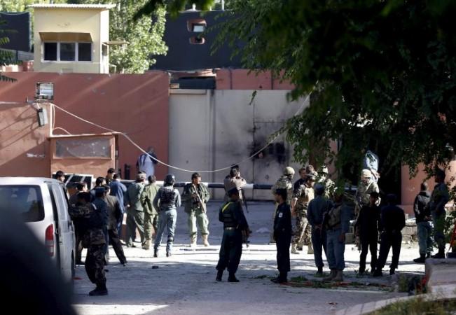 Afghan security force and Nato troops stand at the gate of a guesthouse after an attack in Kabul, Afghanistan
