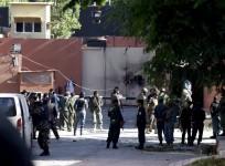 Afghan security force and Nato troops stand at the gate of a guesthouse after an attack in Kabul, Afghanistan