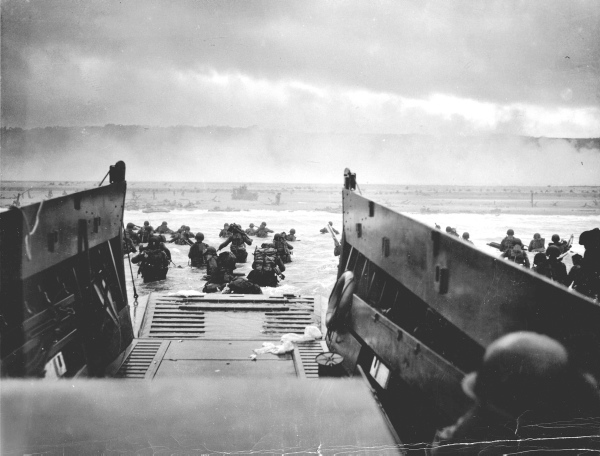 US troops wade ashore from a Coast Guard landing craft at Omaha Beach during the Normandy