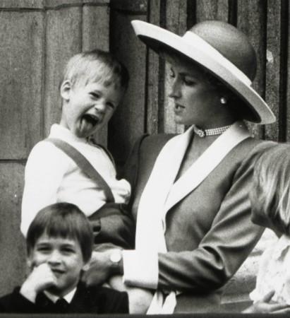 Princess Diana holds Prince Harry as her older son Prince William (L) looks out over the balcony of Buckingham Palace in London on June 11, 1988. Princess Diana
