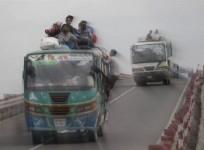 An overcrowded bus drives on a bridge while on a highway near Dhaka
