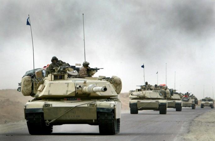 A convoy of US Army 3rd Infantry M1A1 Abrams tanks cross the Euphrates river as black smoke rises after an explosion as hundreds of armored vehicles push towards the outskirts of Baghdad on April 6, 2003. A convoy of US Army 3rd Infantry M1A1 Abrams tanks cross the Euphrates river as black smoke rises after an explosion as hundreds of armored vehicles push towards the outskirts of Baghdad on April 6, 2003.