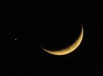 A crescent moon is seen with the planet Jupiter in the sky over Amman December 1, 2008