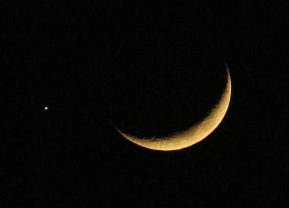 A crescent moon is seen with the planet Jupiter in the sky over Amman December 1, 2008
