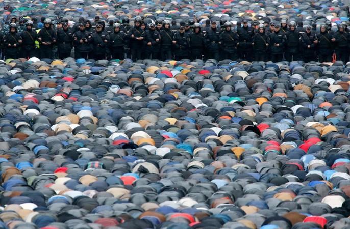 Russian interior ministry members stand guard as Muslims attend an Eid Al-Adha mass prayer in Moscow